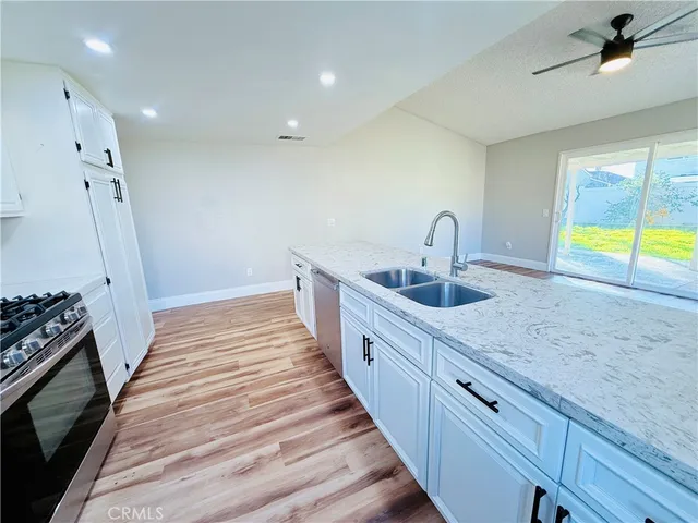 a kitchen with granite countertop a sink and a stove top oven