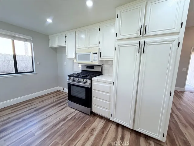 a kitchen with white cabinets and white appliances