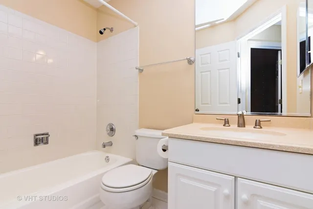 a bathroom with a granite countertop sink toilet mirror and bathtub