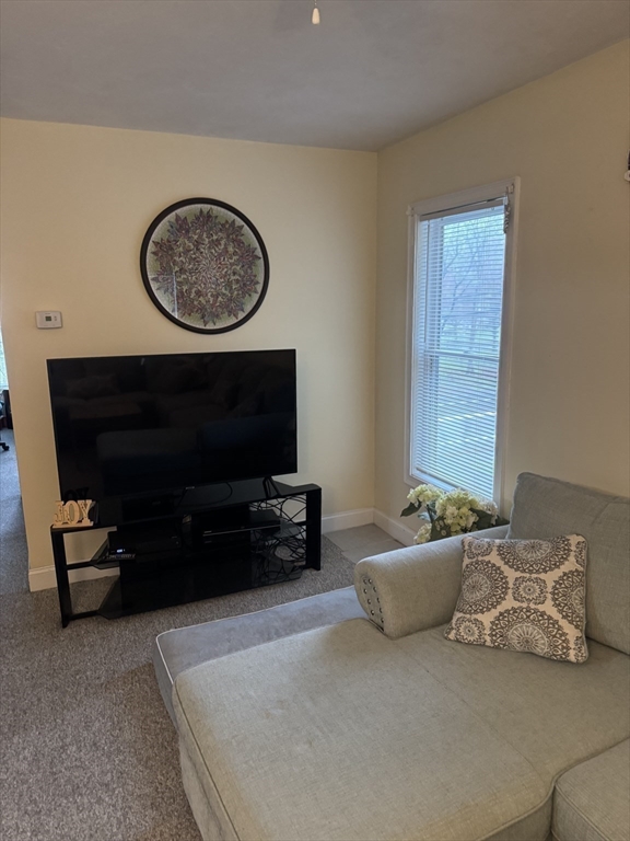 89 Main Street Rowley, MA 01969 - Photo 17 of 39 a living room with a couch and a flat screen tv