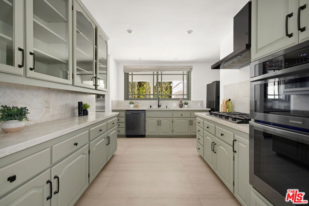 712 North Rodeo Drive Beverly Hills, CA 90210 - Photo 12 of 36 a kitchen with cabinets stainless steel appliances a sink and a window