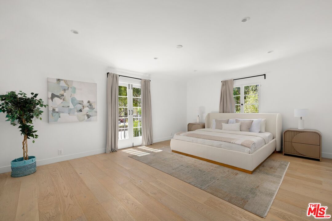 712 North Rodeo Drive Beverly Hills, CA 90210 - Photo 21 of 36 a bedroom with a large bed and a potted plant