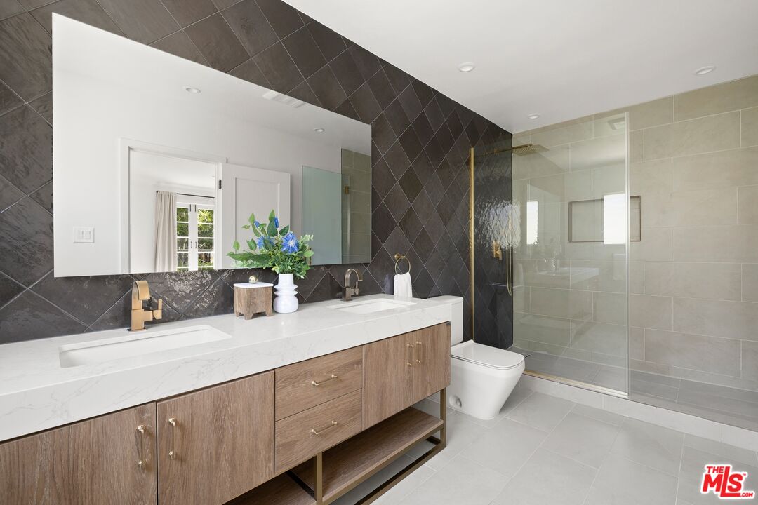 712 North Rodeo Drive Beverly Hills, CA 90210 - Photo 22 of 36 a bathroom with a double vanity sink toilet and shower