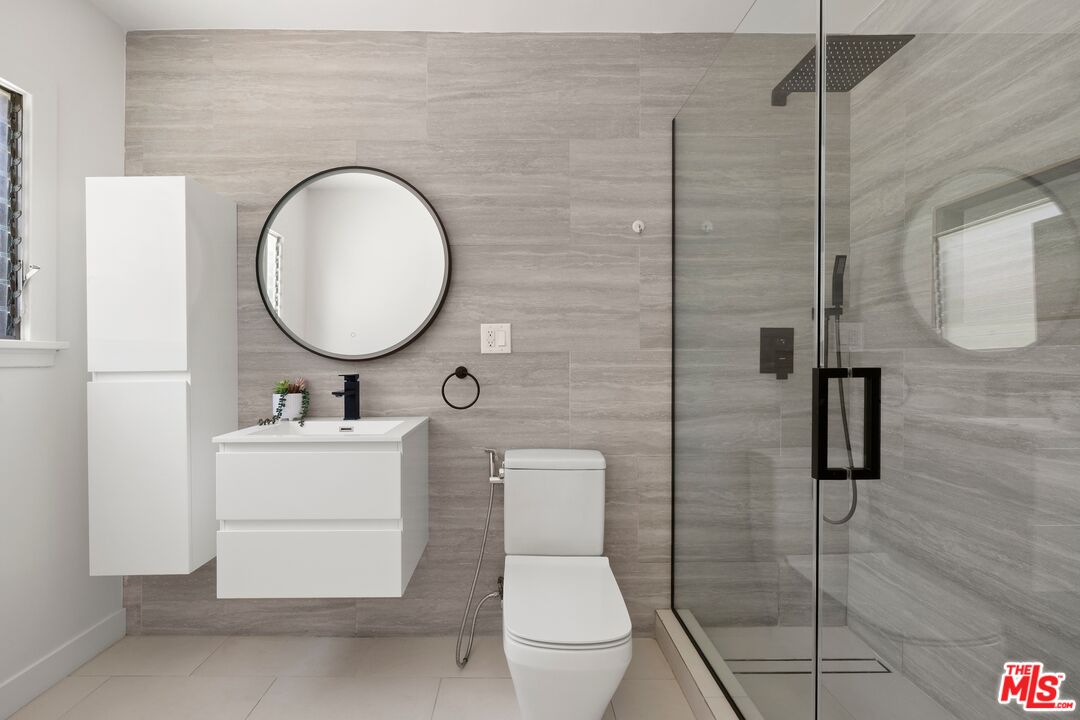 712 North Rodeo Drive Beverly Hills, CA 90210 - Photo 25 of 36 a bathroom with a toilet a sink and mirror