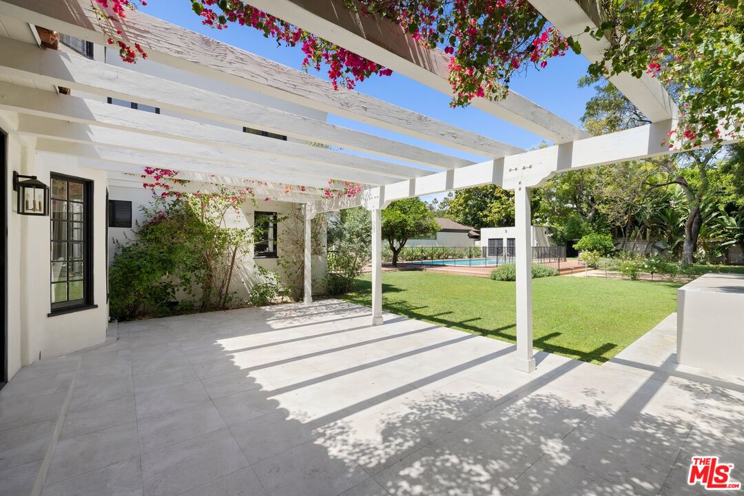 712 North Rodeo Drive Beverly Hills, CA 90210 - Photo 29 of 36 a view of a patio with a table and chairs under an umbrella