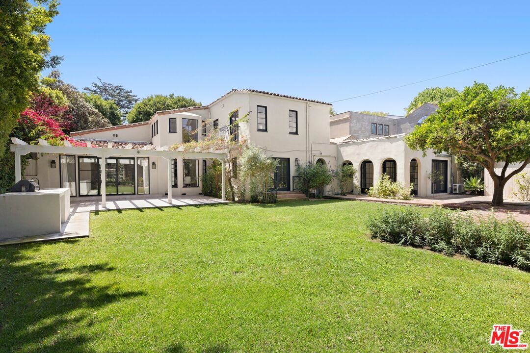 712 North Rodeo Drive Beverly Hills, CA 90210 - Photo 30 of 36 a front view of a house with a yard
