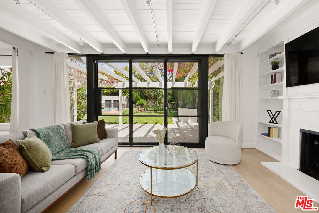 712 North Rodeo Drive Beverly Hills, CA 90210 - Photo 8 of 36 a living room with furniture a flat screen tv and a large window