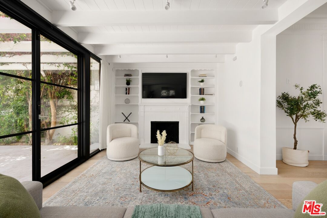 712 North Rodeo Drive Beverly Hills, CA 90210 - Photo 9 of 36 a living room with furniture a flat screen tv and a fireplace
