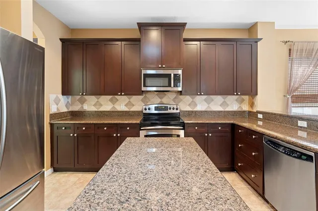 a view of an empty room with a window and chandelier fan