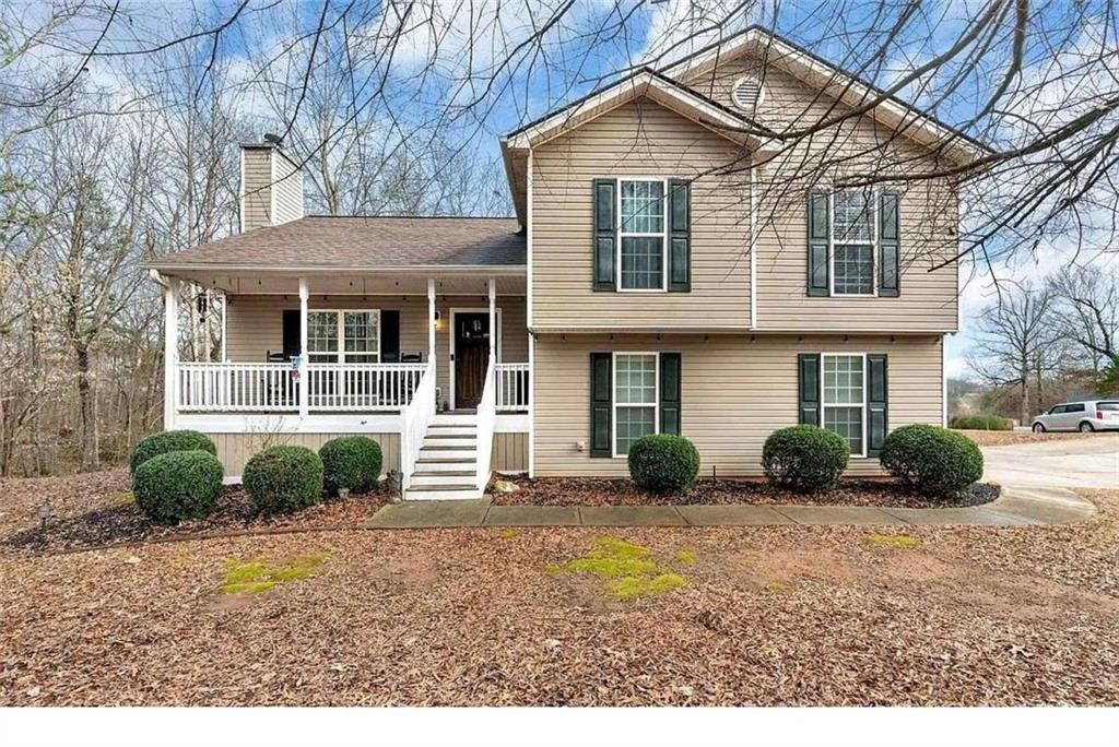 a front view of a house with a yard and potted plants