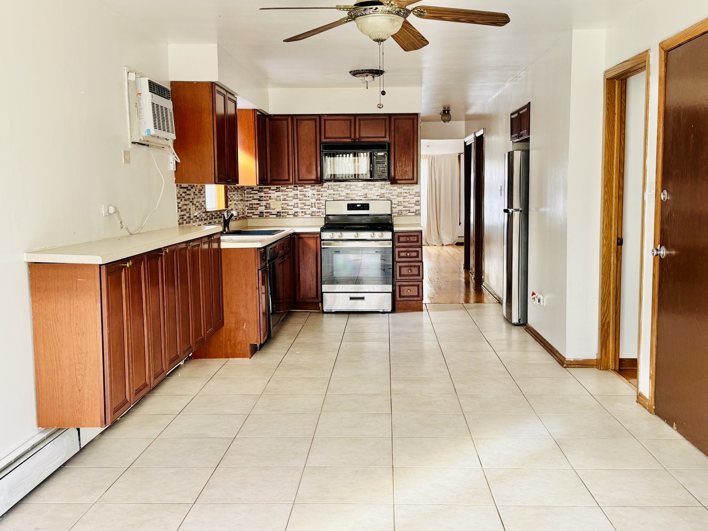 4211 West 63rd Street, Unit 1 Chicago, IL 60629 - Photo 5 of 13 a large kitchen with stainless steel appliances granite countertop a refrigerator and a stove top oven