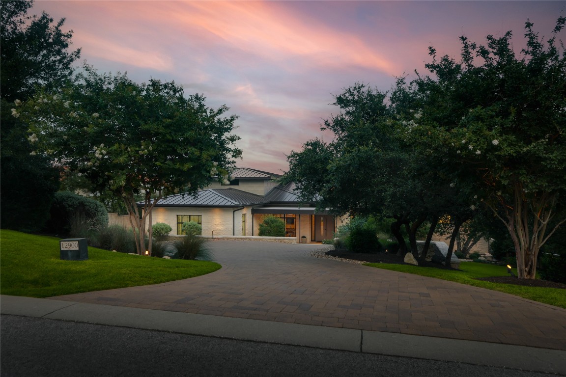 12900 Hacienda Ridge Austin, TX 78738 - Photo 3 of 40 a front view of a house with a yard and trees