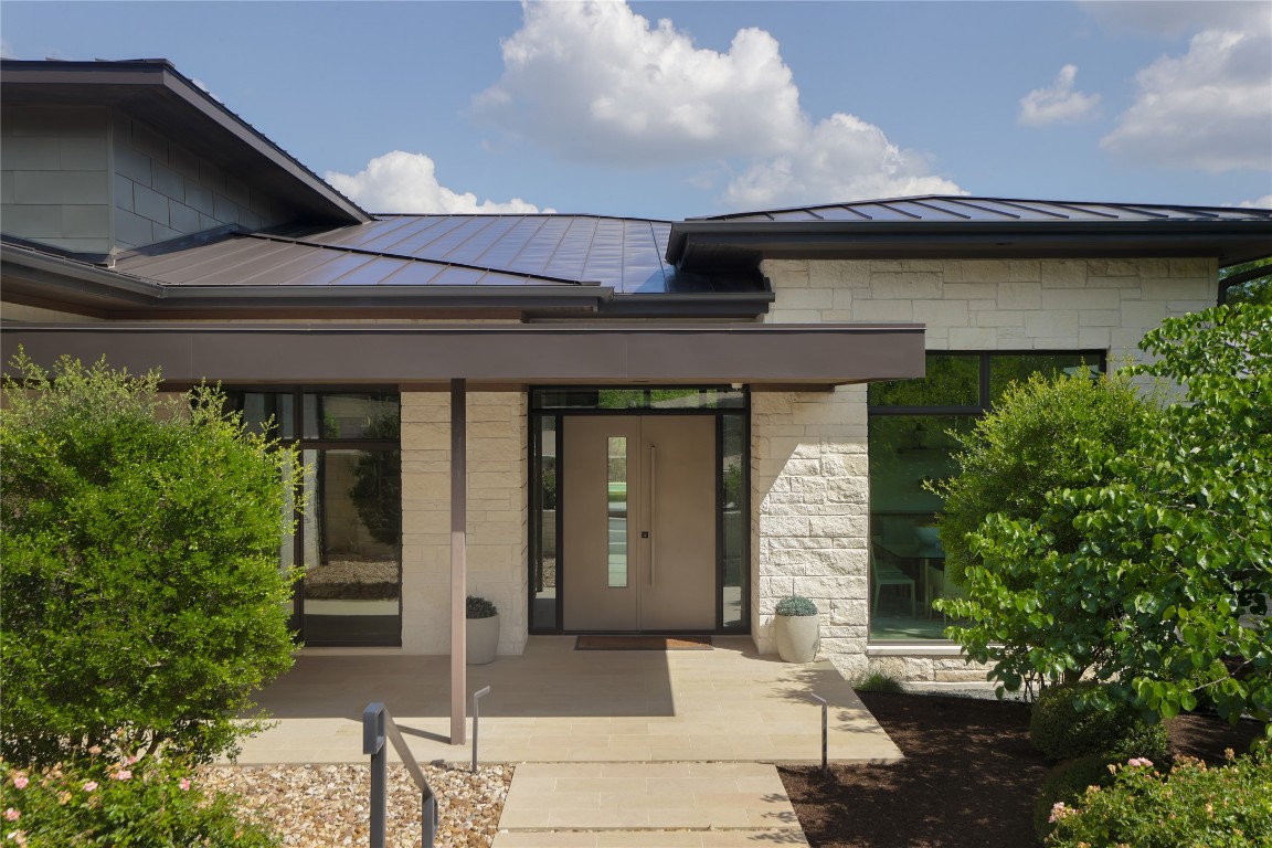 12900 Hacienda Ridge Austin, TX 78738 - Photo 5 of 40 a front view of a house with a garden