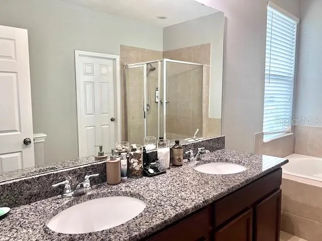 a bathroom with a granite countertop bathtub and shower