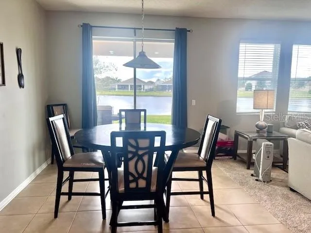 a kitchen with a dining table chairs and refrigerator