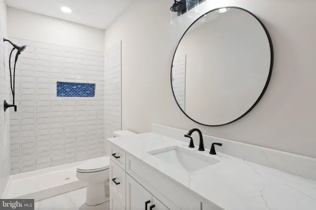 a bathroom with a sink a toilet and a mirror