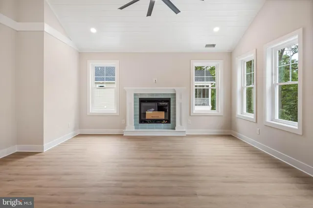 an empty room with windows and fireplace
