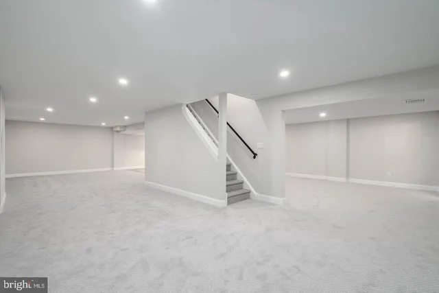 an empty room with staircase and white walls