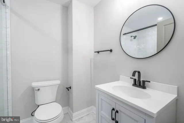 a bathroom with a toilet a sink and mirror