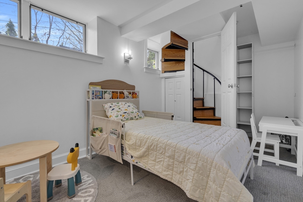 232 Summit Avenue, Unit A1 Brookline, MA 02446 - Photo 15 of 29 a bedroom with a bed a table and chair