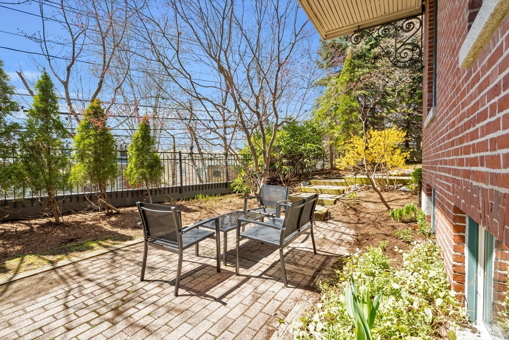 232 Summit Avenue, Unit A1 Brookline, MA 02446 - Photo 24 of 29 a view of a chairs and table in backyard