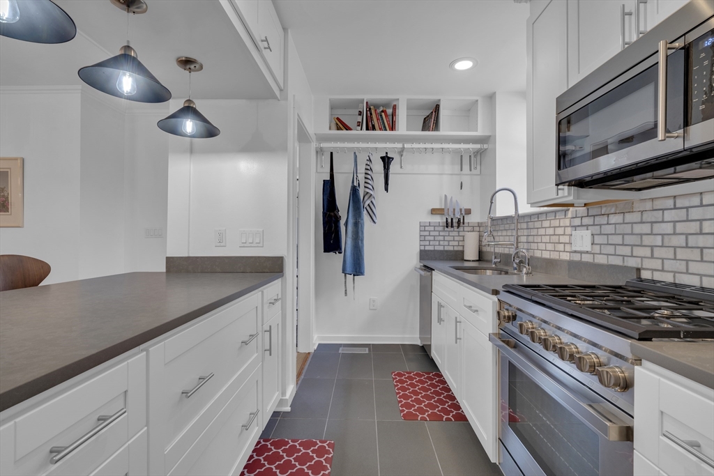 232 Summit Avenue, Unit A1 Brookline, MA 02446 - Photo 7 of 29 a kitchen with stainless steel appliances granite countertop a stove a sink and a refrigerator