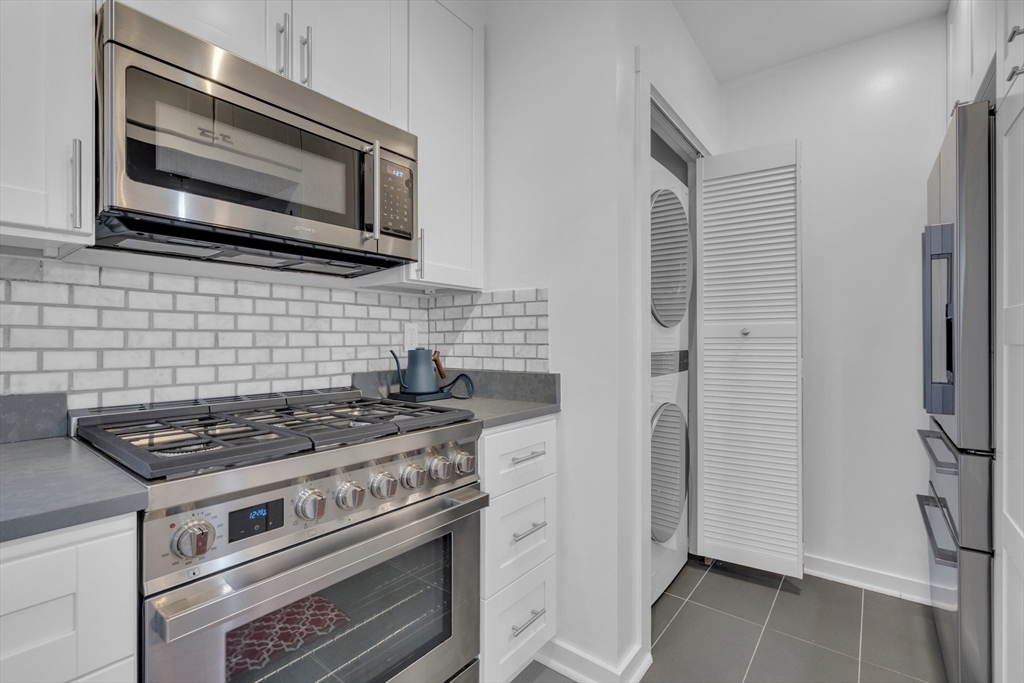 232 Summit Avenue, Unit A1 Brookline, MA 02446 - Photo 8 of 29 a kitchen with stainless steel appliances a stove a microwave and cabinets