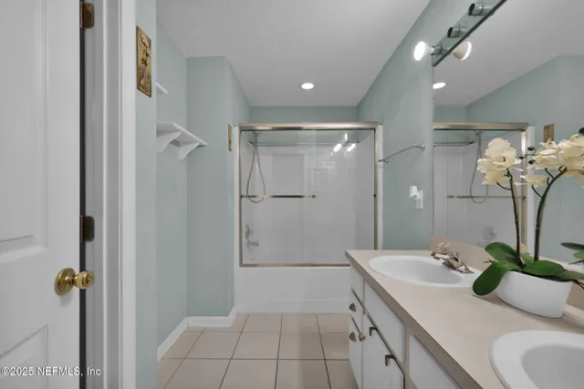 a bathroom with a shower sink and mirror