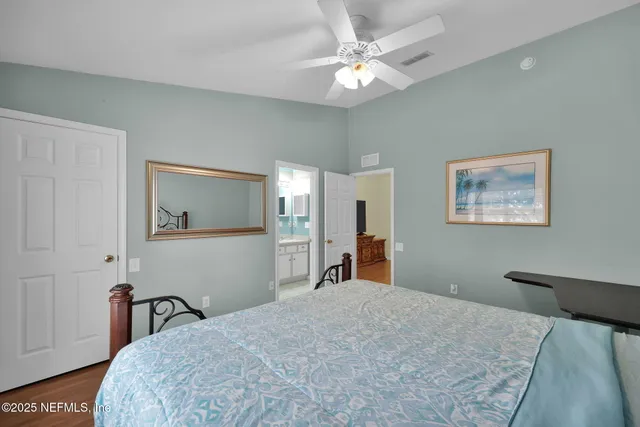 a bedroom with a large bed and a chandelier