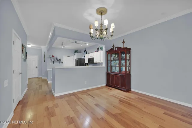 a view of a kitchen with wooden floor and cabinets