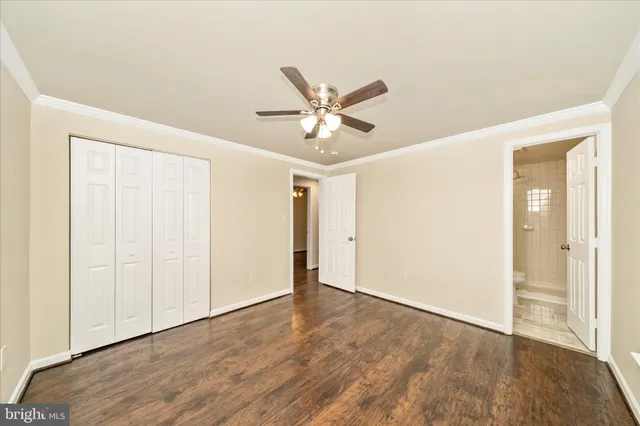 an empty room with wooden floor and ceiling fan