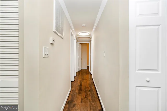 a view of a hallway with a wooden floor and entryway