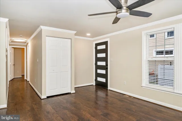 a view of an empty room with a window and wooden floor