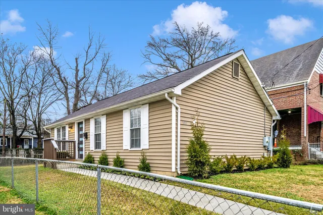 a view of a white house with a large pool plants and large tree