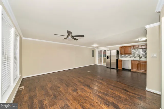 a view of empty room with wooden floor and windows