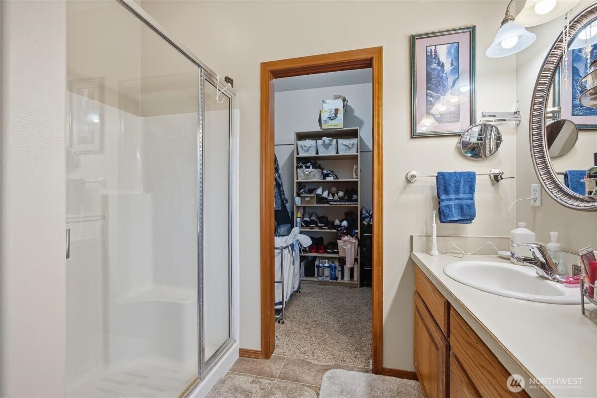 2304 Road 52 Pasco, WA 99301 - Photo 22 of 39 a bathroom with a granite countertop sink a mirror a shower and a sink