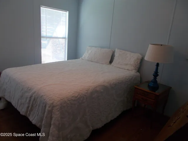 a bed sitting in a bedroom next to a window
