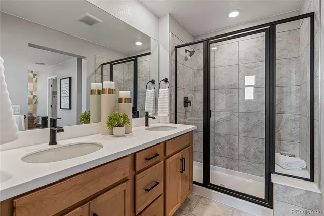a bathroom with a double vanity sink toilet mirror and bathtub