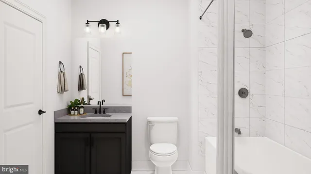 a bathroom with a bathtub sink vanity mirror and toilet