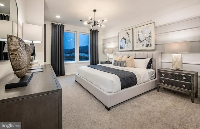 a bedroom with a large bed and a chandelier