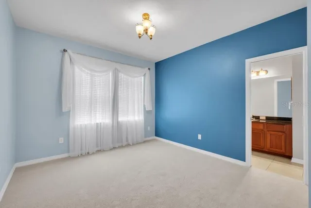 a bathroom with a granite countertop sink a toilet a mirror a bathtub and shower