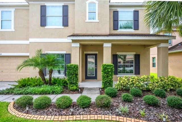 a front view of a house with plants and entryway