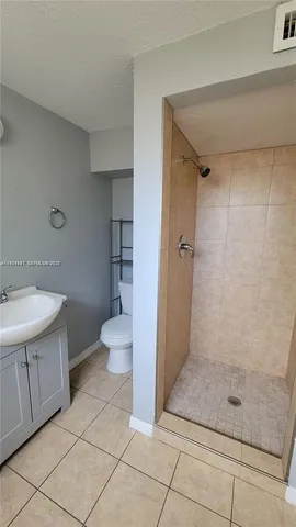 a bathroom with a granite countertop sink a toilet and a mirror