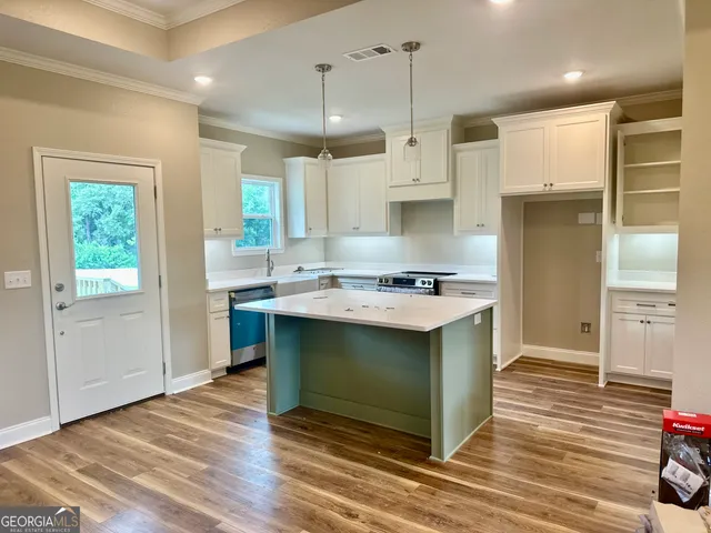 a kitchen with stainless steel appliances granite countertop a sink a stove and a refrigerator