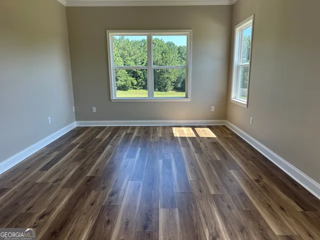 wooden floor in an empty room with a window