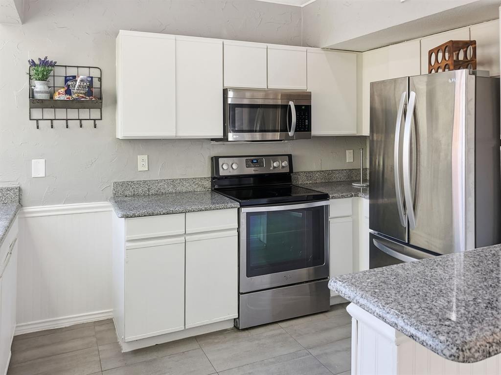 539 Ranch Trail, Unit 172 Irving, TX 75063 - Photo 12 of 40 a kitchen with stainless steel appliances granite countertop a refrigerator stove and microwave