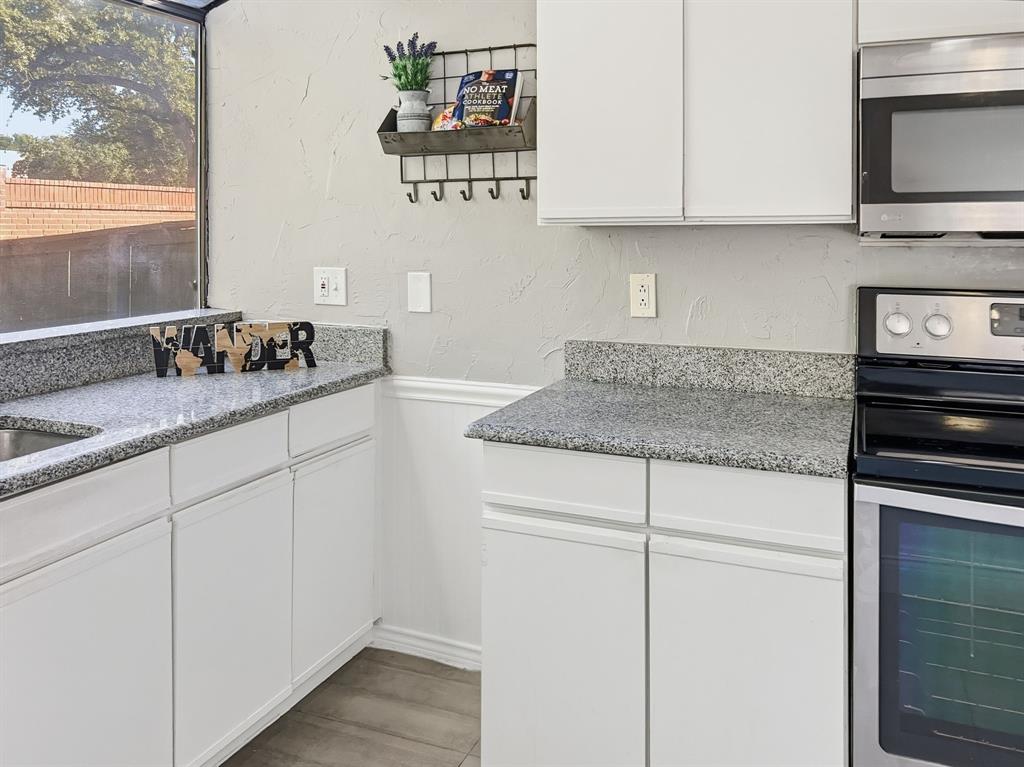 539 Ranch Trail, Unit 172 Irving, TX 75063 - Photo 14 of 40 a kitchen with stainless steel appliances granite countertop a sink stove and microwave