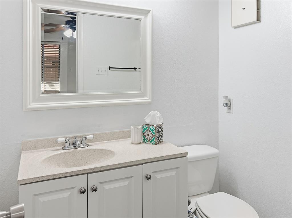 539 Ranch Trail, Unit 172 Irving, TX 75063 - Photo 32 of 40 a bathroom with a sink a toilet and mirror