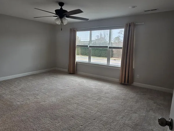 an empty room with a window and a fan