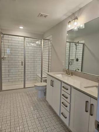 a bathroom with a double vanity sink toilet and shower